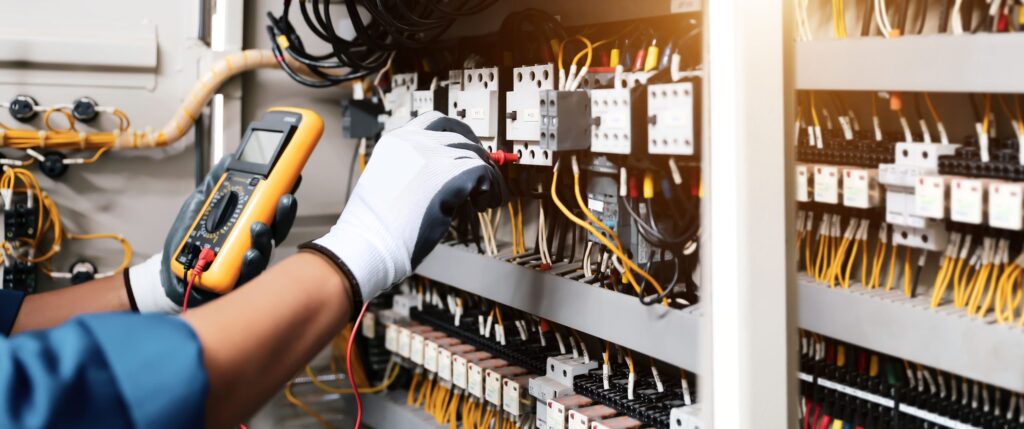 Electrician using a multimeter to trace an electrical fault