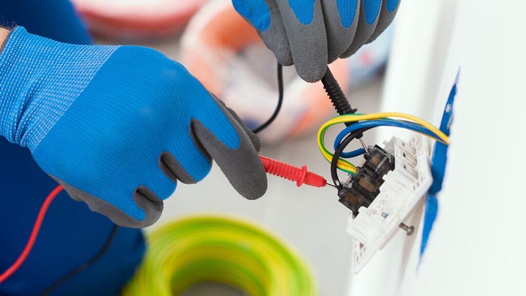 Electrician wiring a light fitting against a clean white wall